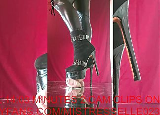 Mistress Elle wearing her studded boots grinds her slaves cock
